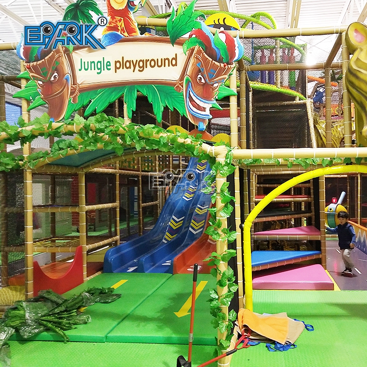 Large indoor playground structure with colorful climbing nets, slides, tunnels, and soft play areas for children to climb, jump, crawl, run, and play group games.