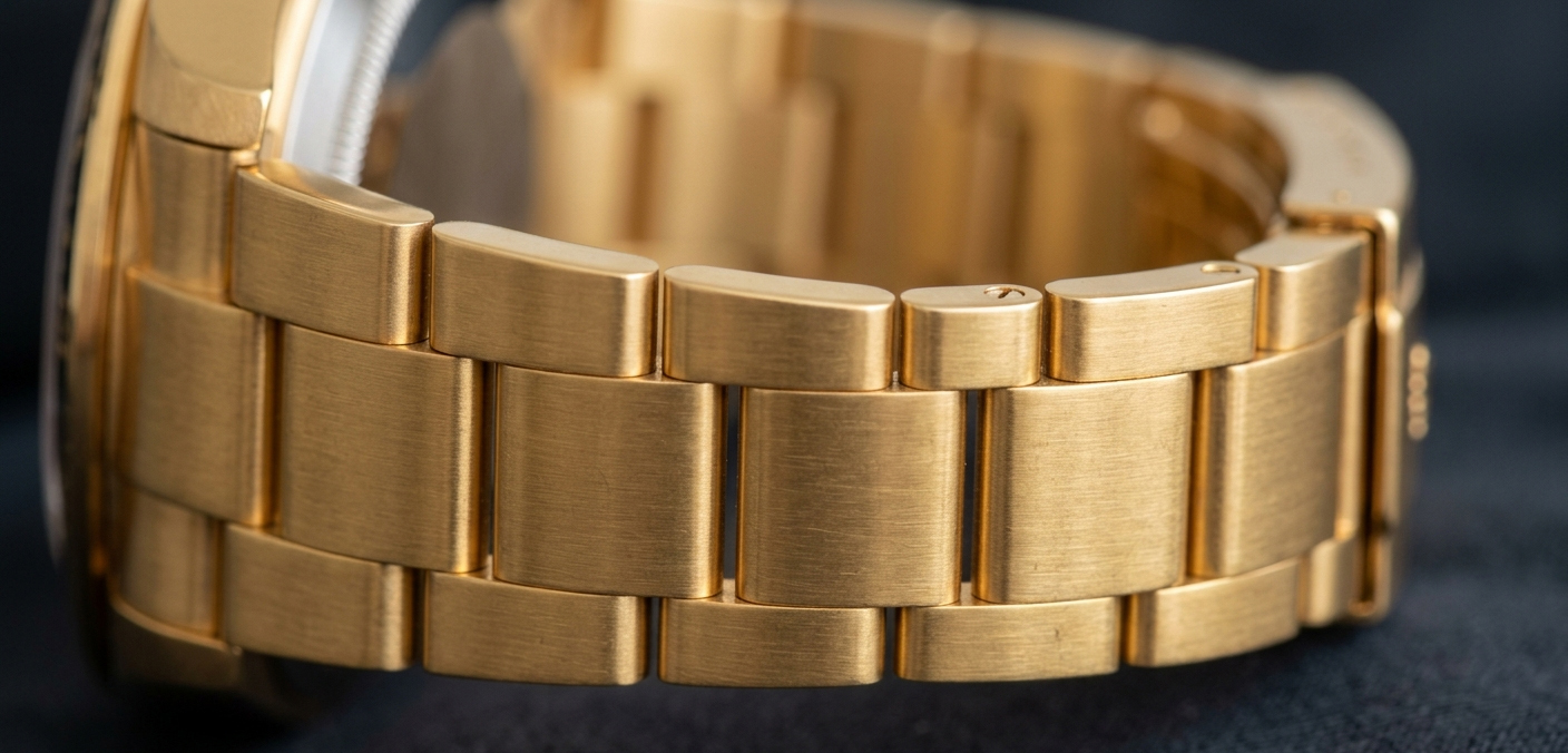 A macro photo of a gold-toned PVD coated stainless steel watch band showing the uniform, dense color.